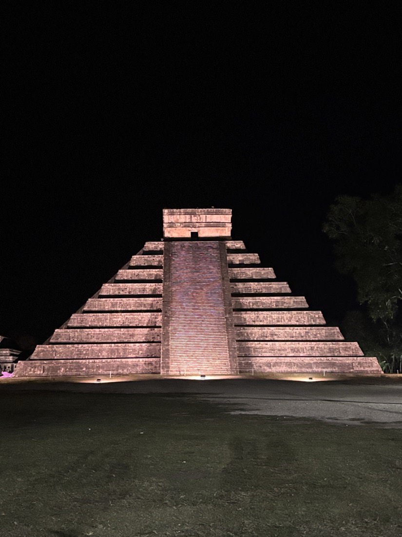 Pirámide arqueológica iluminada de rosa por la noche