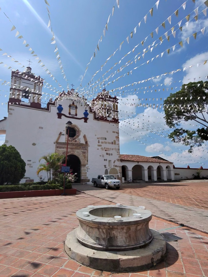 Fachada de una iglesia colonial adornada con papel picado